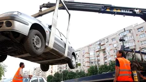 Maşină parcată neregulamentar ridicată de poliţişti cu tot cu un copil dormind în ea