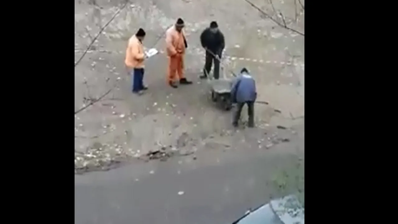 Asfaltare „modernă” la Galaţi. Patru muncitori transportă apă de ploaie cu lopata şi roaba | VIDEO