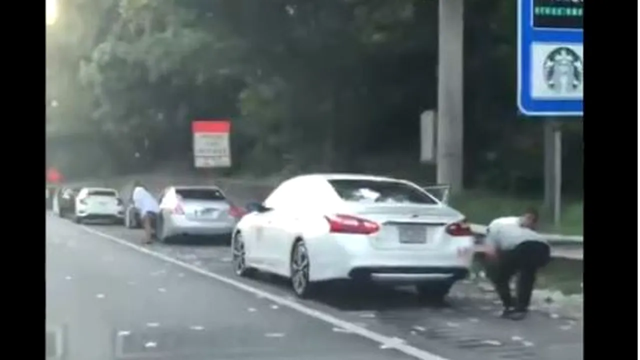 „Furtună” de bani, pe o autostradă. Şoferii au oprit brusc şi au „vânat” bancnotele luate de curenţii de aer. Suma de bani care şi-a luat zborul | FOTO, VIDEO