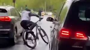 VIDEO: O clipă de neatenţie îl putea costa viaţa pe un biciclist. Câţiva milimetri l-au despărţit de roţile unei maşini