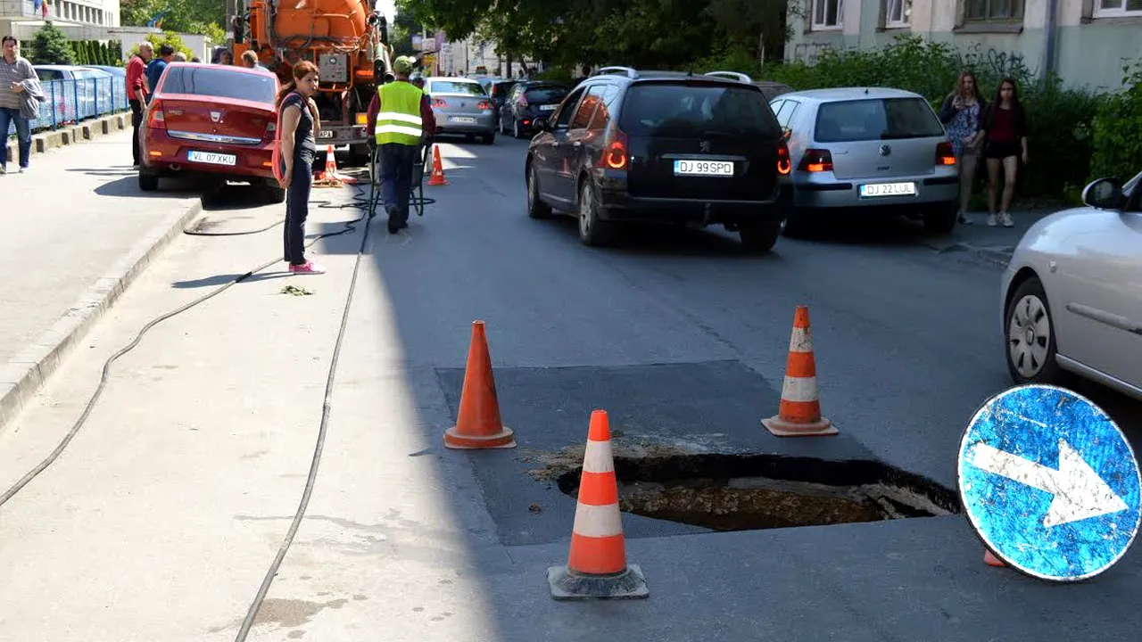 Restricţii de circulaţie pe o stradă din Craiova după ce asfaltul s-a surpat în urma unei avarii - FOTO
