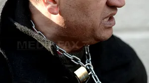 Un bărbat a protestat la DNA legat cu un lanţ de grilajul unei ferestre - FOTO