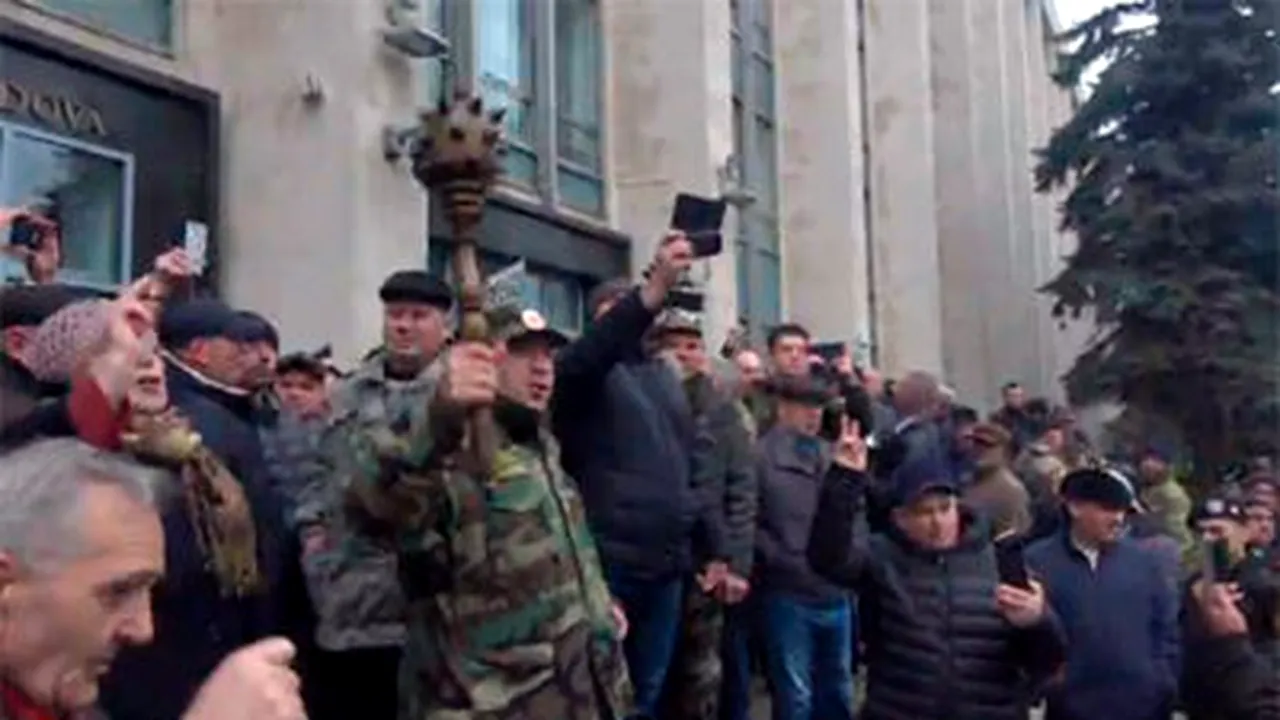 VIDEO: Uşa de la intrarea în Guvernul Republicii Moldova spartă cu buzduganul de un protestatar