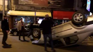Grav accident în Bucureşti: un autoturism s-a răsturnat după ce a lovit un vehicul staţionat - FOTO