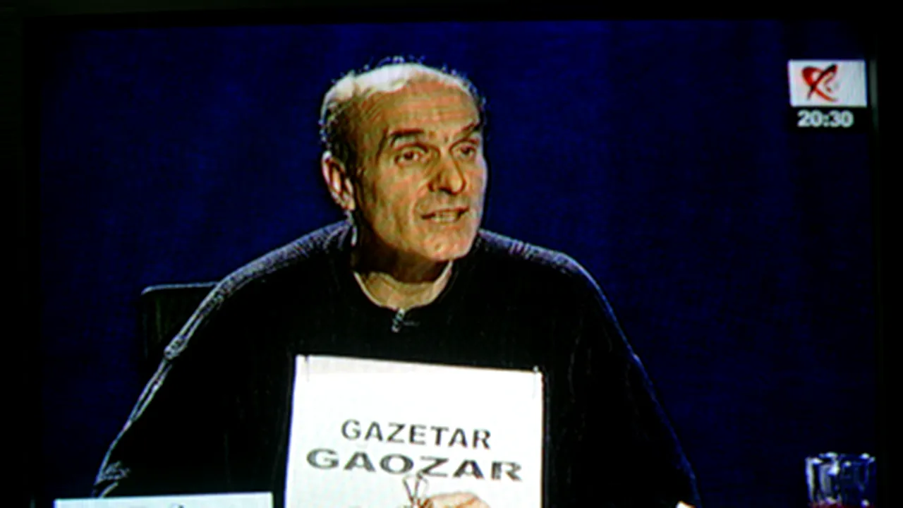Cristian Tudor Popescu protestează cu o pancartă pe care scrie „Gazetar Găozar“