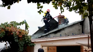 O bătrână imobilizată la pat, salvată de vecini după ce acoperişul casei a luat foc