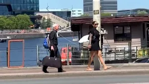 Femeie filmată în timp ce se plimbă și ține în lesă un bărbat cu părul alb