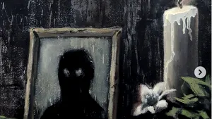 Un altar cu o fotografie a unei feţe de culoare şi o flacără care arde colţul steagului SUA. Lucrarea lui Banksy în memoria lui George Floyd 

