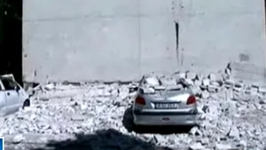 Izolaţia unui bloc din Capitală a căzut peste două maşini parcate - VIDEO