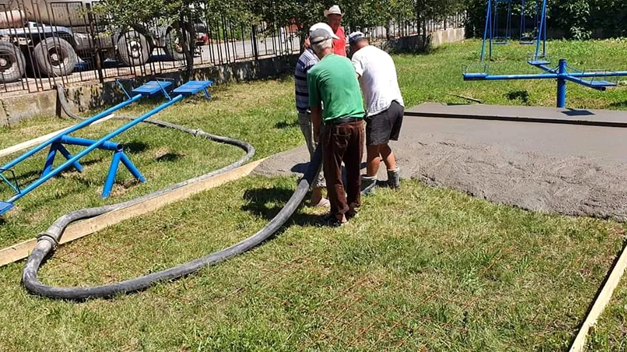 IMAGINI cu muncitorii care toarnă ciment direct pe iarbă, la o grădiniţă din Dolj. Primarul: A rămas de la alte lucrări şi nu ştiau unde să îl ducă