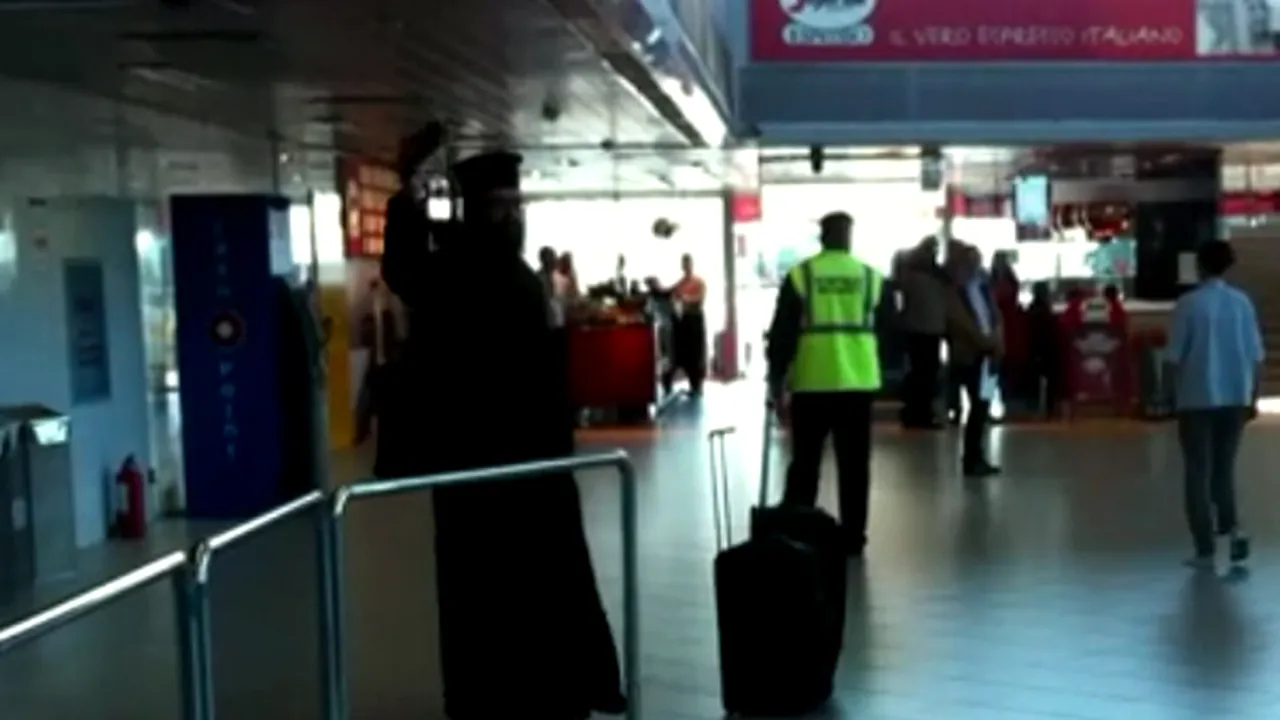 SCANDAL PE AEROPORTUL OTOPENI: Un bărbat îmbrăcat în preot a înjurat Biserica, preşedintele şi pe toţi cei din jur. Patriarhia spune că nu e cleric - VIDEO 