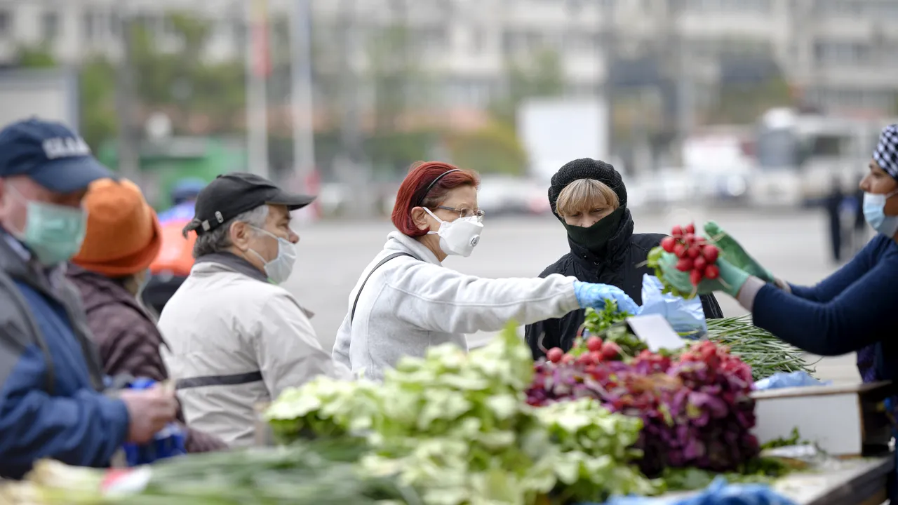 A venit zăpada-n pieţe! Producătorii locali îşi acoperă legumele cu pături şi poartă 5 rânduri de haine ca să se protejeze de frig