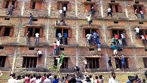 IMAGINI inedite: Părinţi ai unor elevi din India, căţăraţi pe zidurile unei şcoli pentru a-i ajuta să copieze - VIDEO