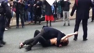 VIDEO | Momentul în care o activistă Femen topless este pusă la pământ de un jandarm