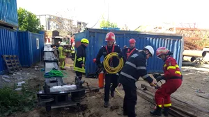 FOTO Operaţiunea de salvare contra cronometru a eşuat. Bărbatul prins sub un container pe un şantier din Bucureşti a fost scos decedat
