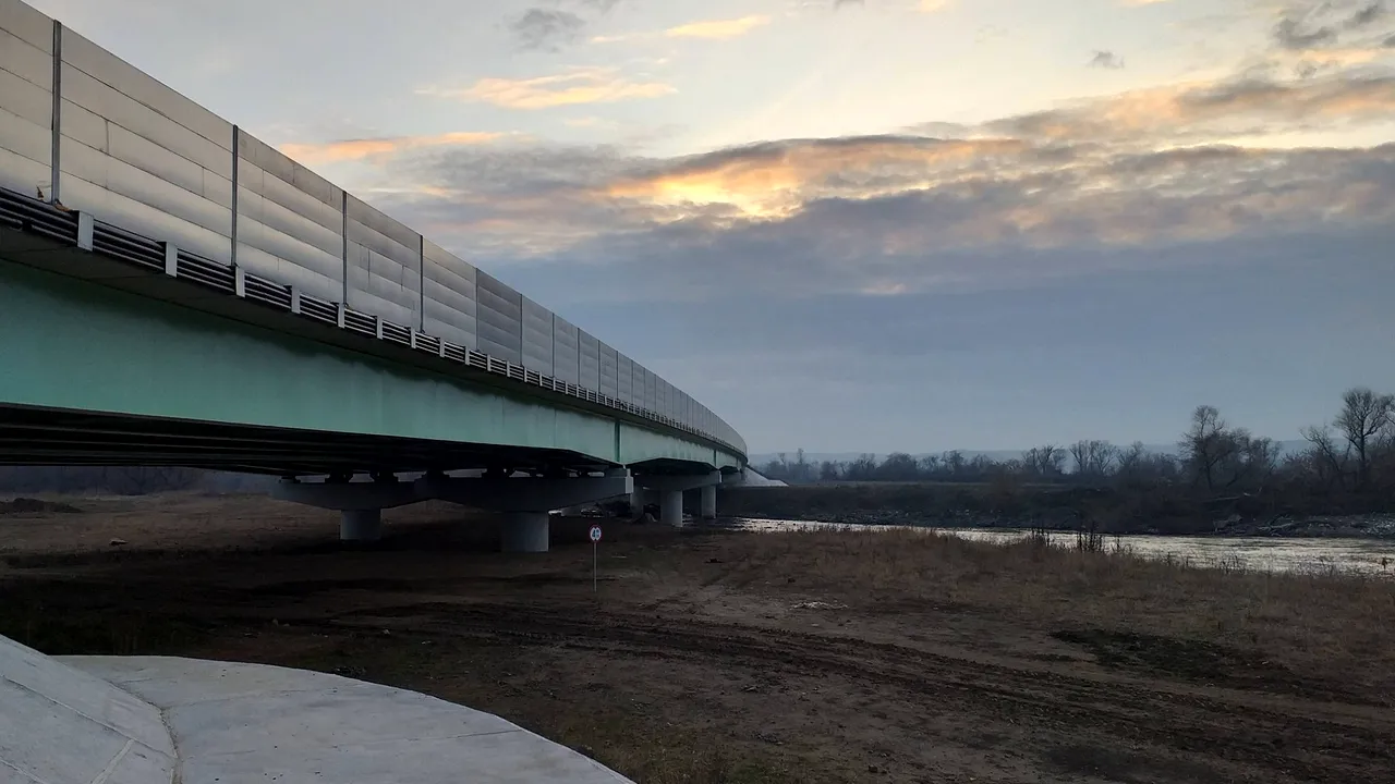 Lotul de autostradă terminat, dar care nu are panglica tăiată din cauza lucrărilor la un pod. Asociaţie: Este o bătaie de joc