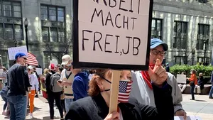 Fotografia cu femeia care a folosit sloganul nazist „Arbeit macht frei” de la Auschwitz ca mesaj de protest faţă de şomaj, virală