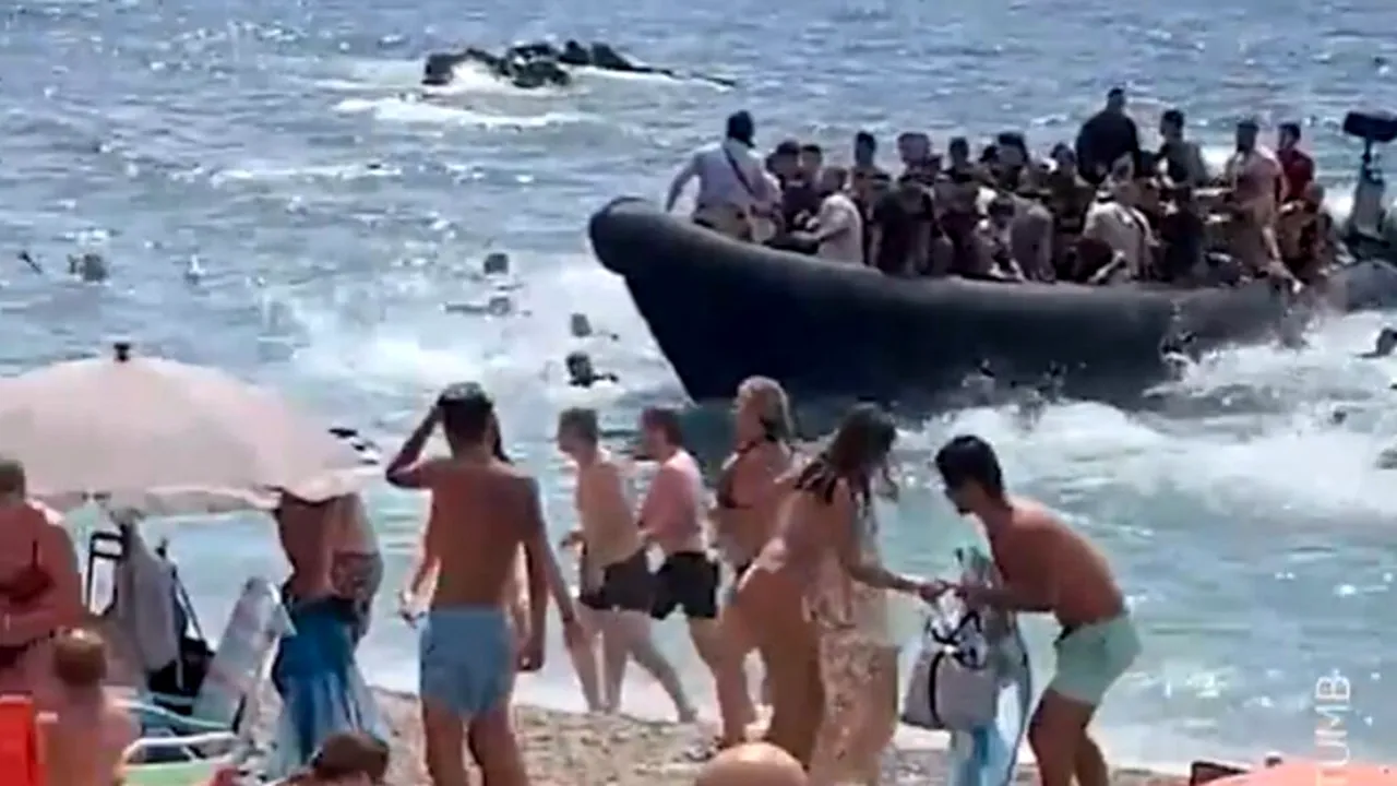 [VIDEO] Momentul în care o barcă plină cu migranți, majoritatea bărbați, ajunge pe o plajă plină de turiști din Spania