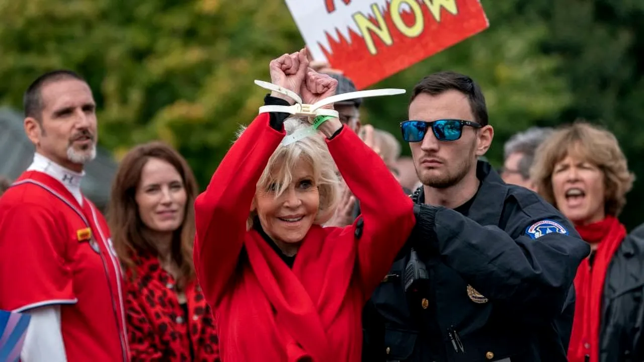 Gestul făcut de Jane Fonda în timp ce era arestată. Actriţa a mulţumit peste umerii poliţiştilor pentru premiul de excelenţă acordat de BAFTA - VIDEO