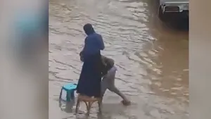 Un bărbat sare în ajutorul unei femei care încearcă să traverseze o stradă inundată - VIDEO