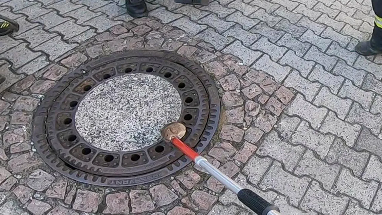 Eforturi dramatice pentru salvarea unui şobolan gras, rămas înţepenit într-un capac de canalizare | FOTO, VIDEO