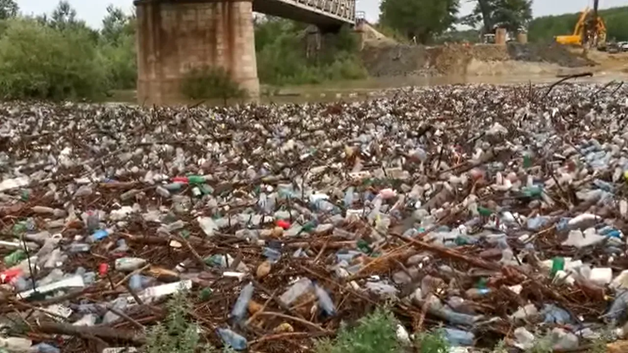 VIDEO Cantităţi uriaşe de pet-uri, gunoaie şi crengi aduse de viitură pe râul Olteţ, în urma ploilor abundente