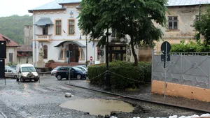 FOTO VIDEO Stradă din Slatina închisă după ce un crater s-a format din cauza ploilor / Clădirea unui liceu, cea a unei firme de curierat şi a unei fabrici, inundate