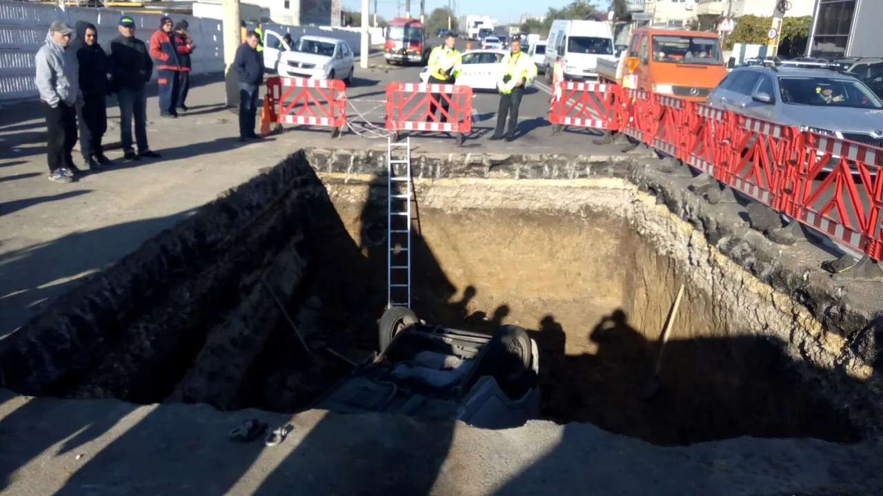 O maşină a căzut într-o groapă de cinci metri, pe o stradă din Constanţa, peste un muncitor care înlocuia conducte | FOTO