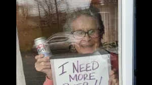 Imaginea virala a izolării. O femeie de 93 de ani a transmis la fereastră mesajul: „Am nevoie de mai multă bere”. Ce a urmat