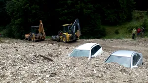 GALERIE FOTO | Două maşini au fost îngropate în piatra adusă de viitură în Zărneşti