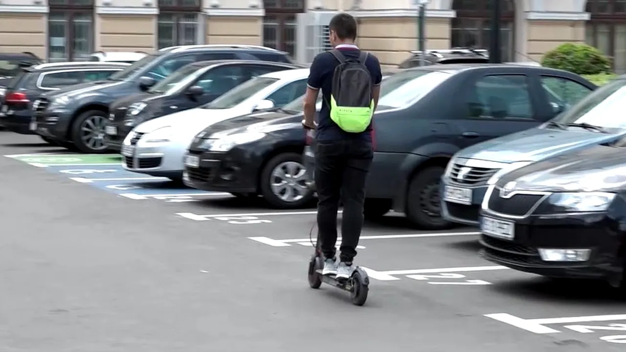 Job modern, dar pretenţios. Alexandru, angajat la primăria Iaşi, verifică parcometrele folosind trotineta electrică