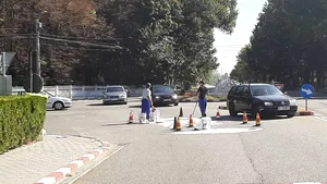 Doi angajaţi ai unei primării, filmaţi în timp ce încercau să recupereze cu lopata vopseaua de pe stradă