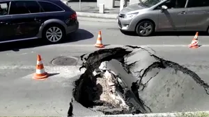 Crater într-o intersecţie din Capitală. O maşină a fost „înghiţită” de asfalt, după ce strada s-a surpat/ Apa Nova: Surparea nu se datorează reţelelor de apă potabilă şi canalizare | FOTO, VIDEO