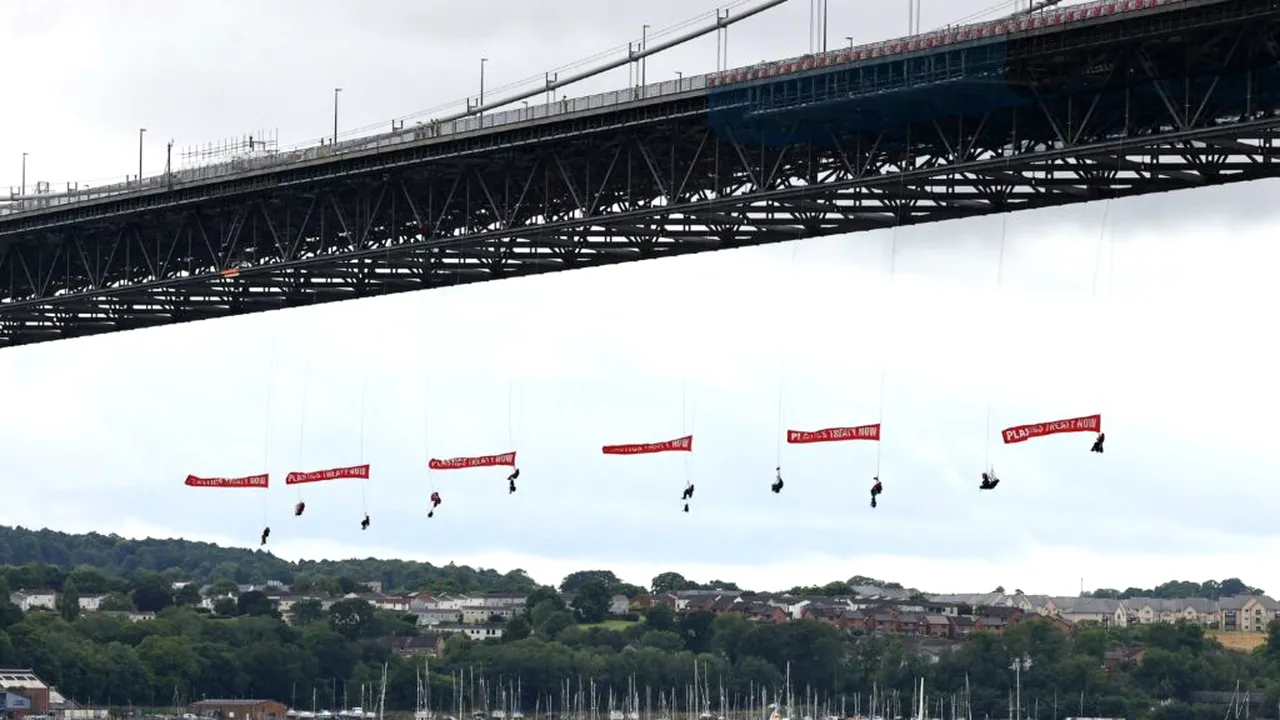 Protest inedit Greenpeace: activiștii s-au suspendat de un pod, blocând traficul naval