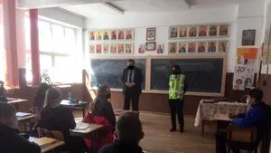 De-a râsu'-plânsu'. Unui profesor de la Suceava i-a fost desenată pe faţă o mască de protecţie, în Photoshop. Fotografia, făcută într-o sală de clasă, cu elevi, la o acţiune a Poliţiei