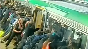 Zeci de pasageri au împins vagonul unui tren pentru a ajuta un bărbat care căzuse - VIDEO