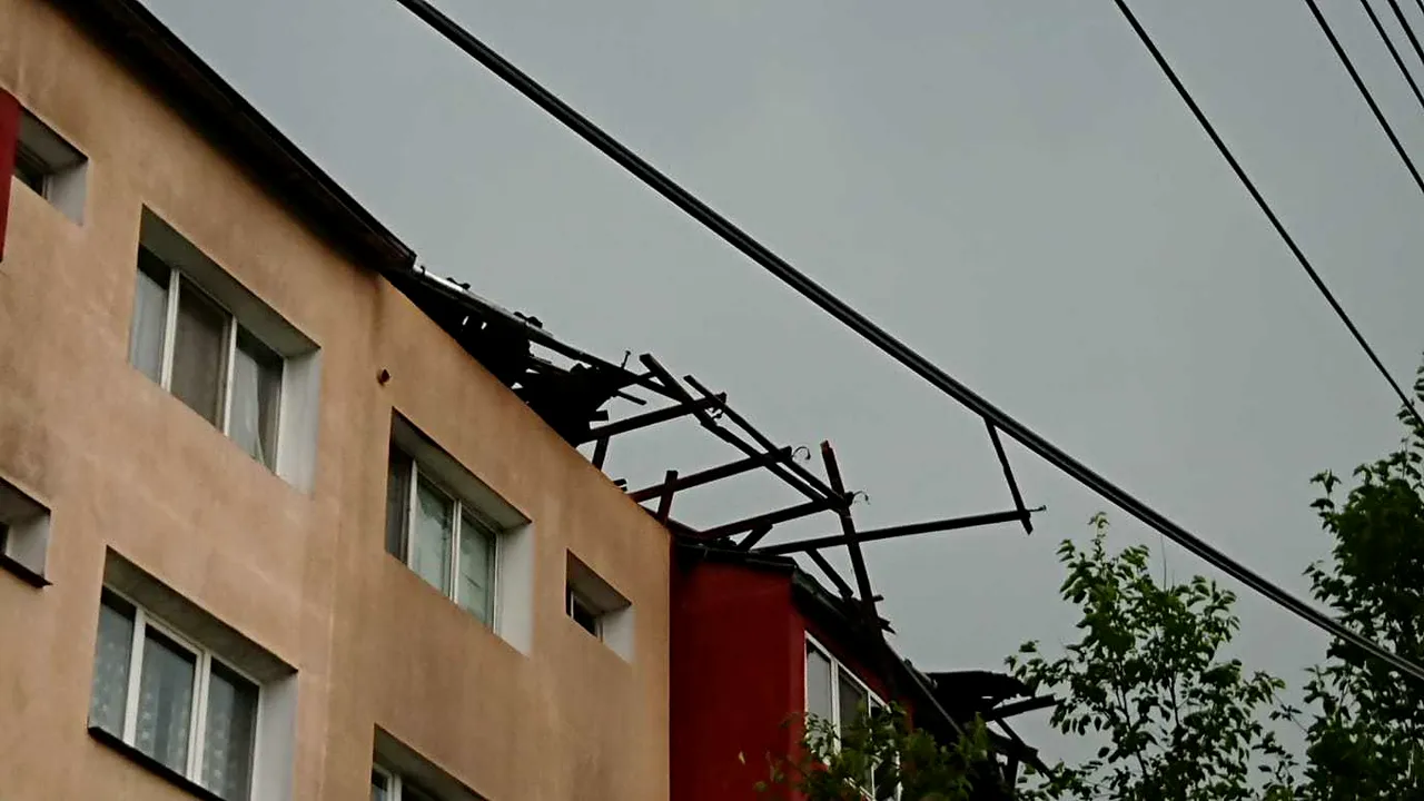 Furtună violentă la Reşiţa: Trei maşini avariate de un acoperiş luat de vânt | FOTO