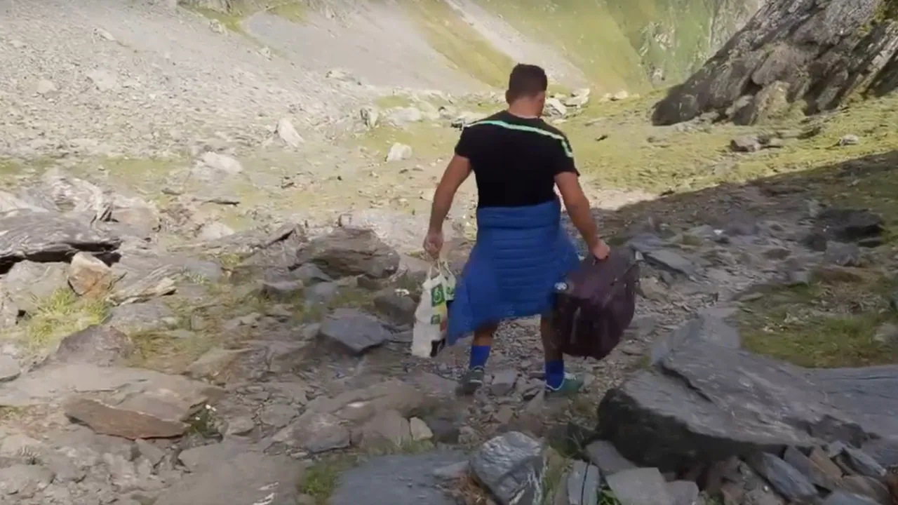 VIDEO Un bărbat a parcurs traseul Bâlea Lac- Moldoveanu cu trolerul în mână şi o boxă din care răsuna muzica populară