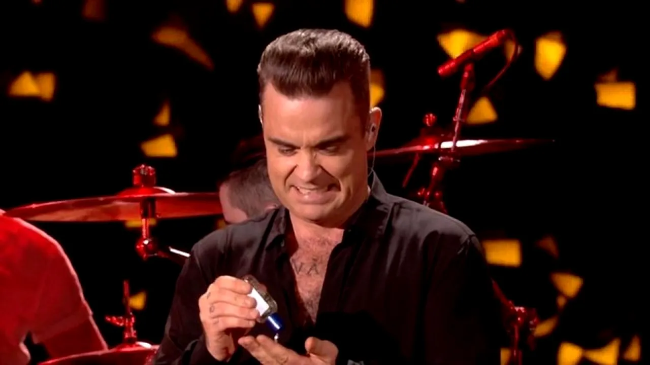 VIDEO Robbie Williams le răspunde fanilor care l-au ironizat pentru că s-a dat cu gel antibacterian pe scenă:  