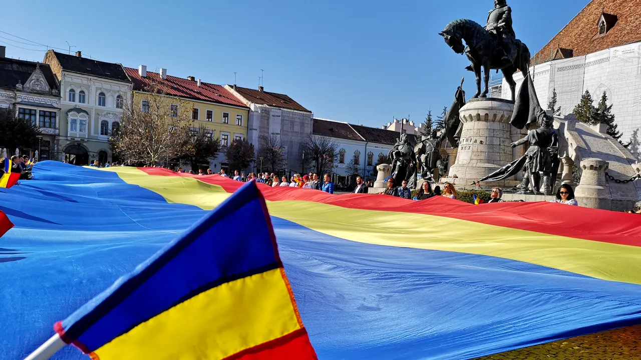 Tricolor de mari dimensiuni, desfăşurat în centrul oraşului Cluj-Napoca, în cadrul unei caravane | GALERIE FOTO