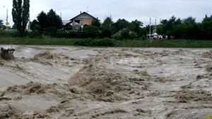 Gospodării inundate într-o localitate din Suceava, pompierii consolidează un dig