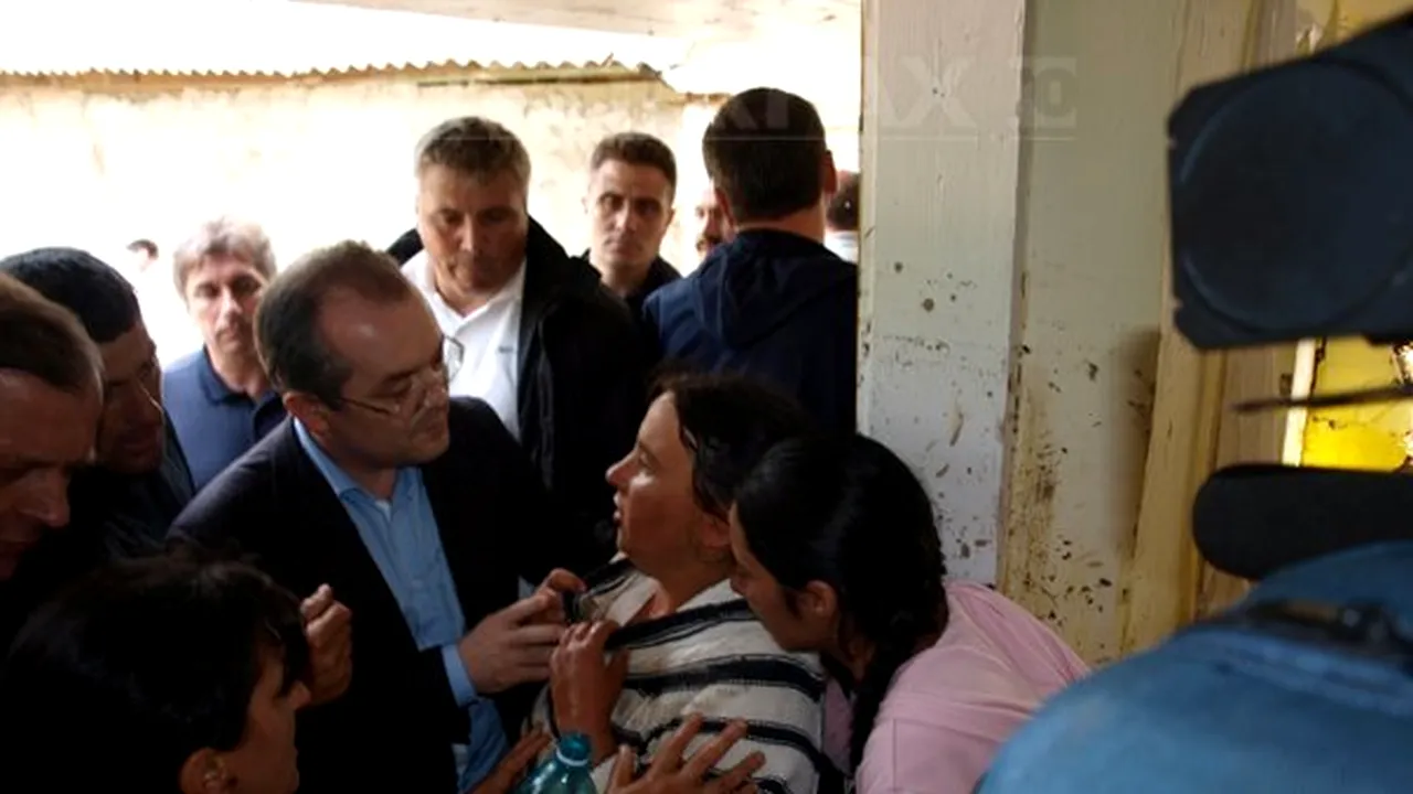 O femeie a leşinat în braţele lui Boc în timp ce premierul îi vizita casa afectată de inundaţii - GALERIE FOTO