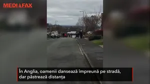 Oamenii dansează împreună pe stradă, într-un orăşel din Anglia, pentru a-i înveseli pe cei izolaţi