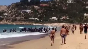 IMAGINILE ZILEI O barcă cu imigranţi ajunge pe o plajă plină de turişti, în Spania