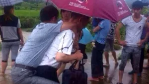 Oficial chinez cărat în spate într-o zonă inundată, demis în urma unui scandal pe Internet - FOTO