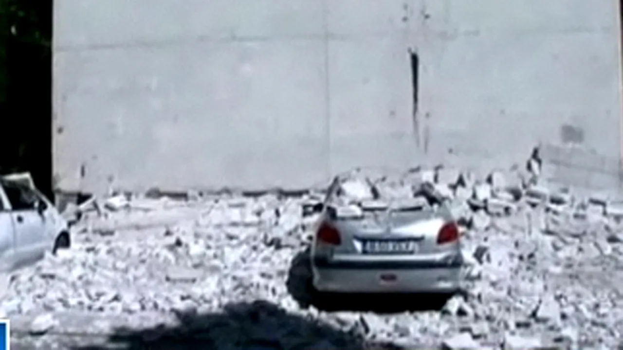 Izolaţia unui bloc din Capitală a căzut peste două maşini parcate - VIDEO