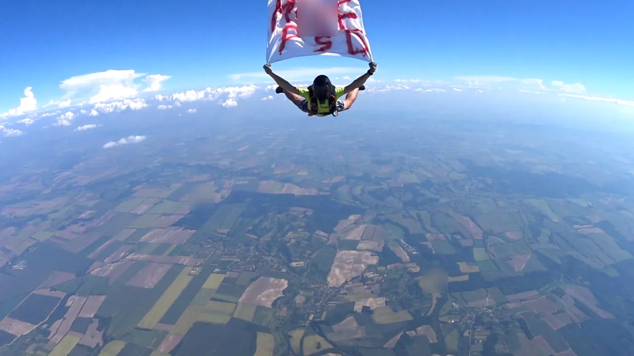 VIDEO Un paraşutist a sărit din elicopter, de la o altitudine de 4.000 metri, cu mesajul M...PSD