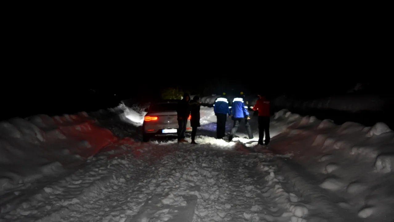 FOTO Cinci turişti, printre care doi minori, blocaţi în zăpadă pe Transalpina, ajutaţi să coboare de jandarmi
