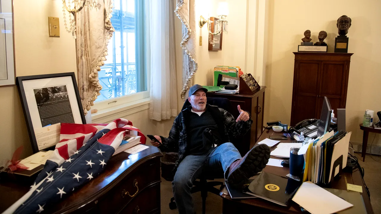 FOTO Imaginile asaltului asupra Capitoliului. Un susţinător al preşedintelui Donald Trump, cu picioarele pe un birou din Congresul SUA