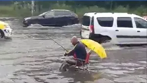 Bărbat filmat în timp ce ”pescuia”, în mijlocul unei străzi inundate din Bucureşti. Cum au reacţionat şoferii din trafic | VIDEO
